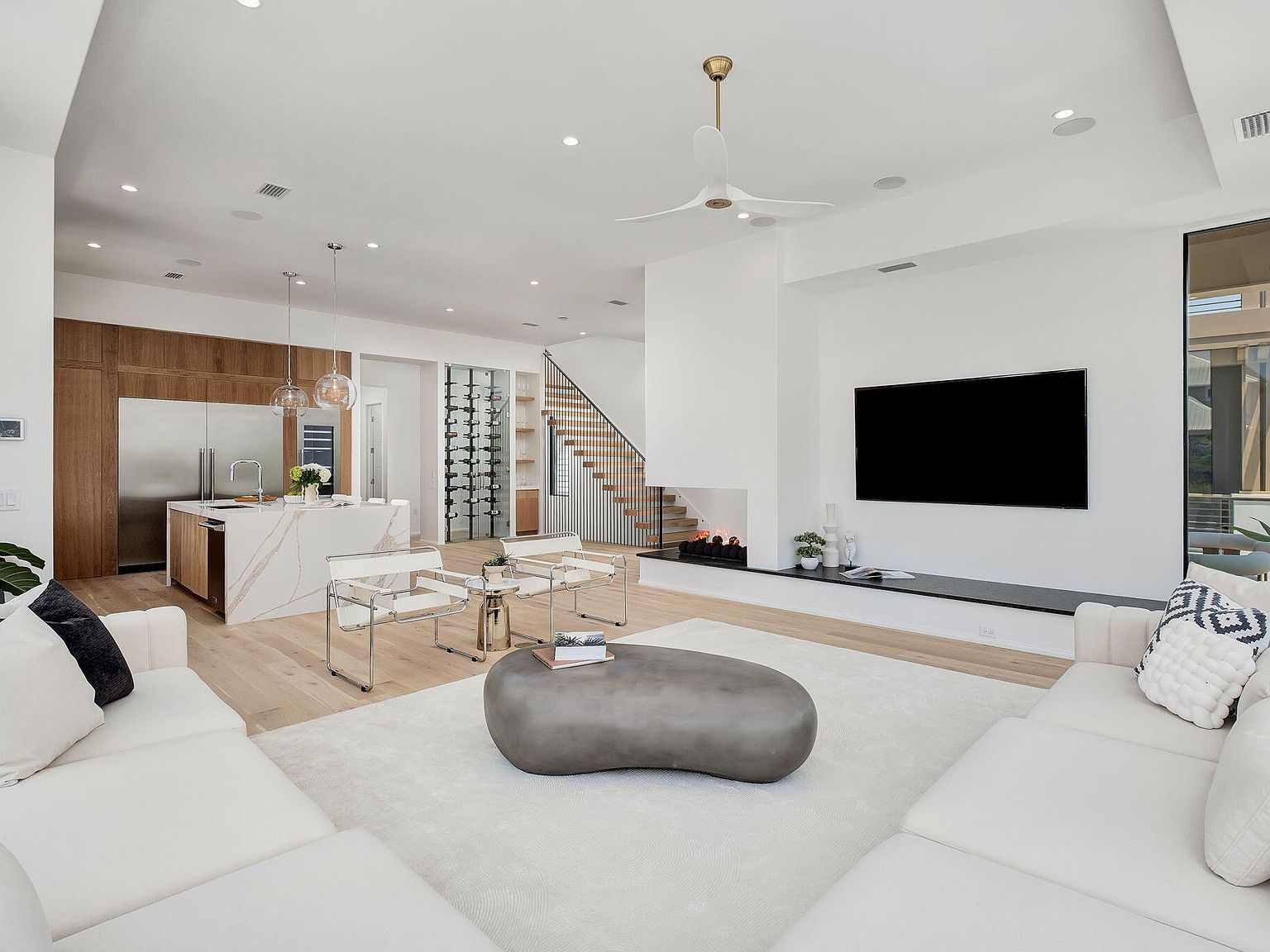 Open concept living room, kitchen, and wine wall